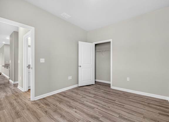 A room with a white door and a wooden floor.