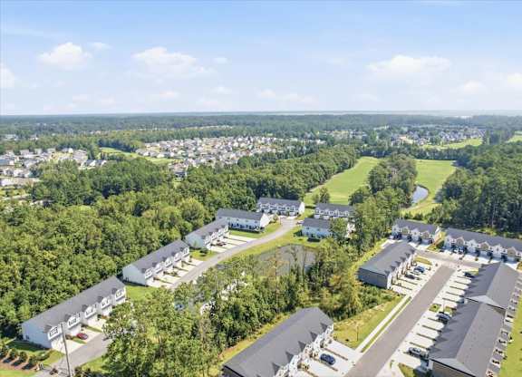 A bird's eye view of a residential area with houses and a parking lot.
