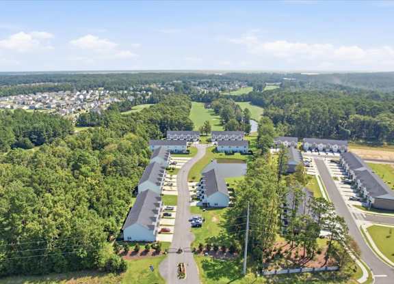 A bird's eye view of a residential area with houses and a parking lot.