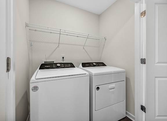 A white laundry room with a washer and dryer.