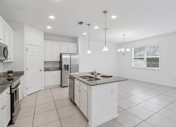 A kitchen with white cabinets and a granite countertop.