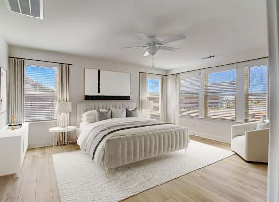 A bedroom with a large bed and a ceiling fan.