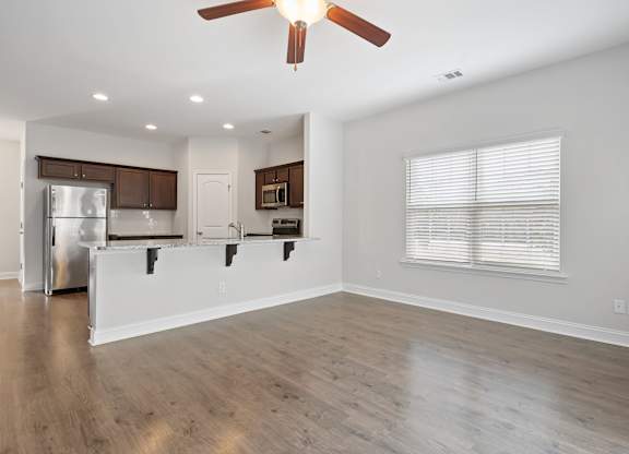 Harris Trail Luxury Townhomes for rent Richmond Hill, GA photo of an empty living room hardwood floors and a ceiling fan