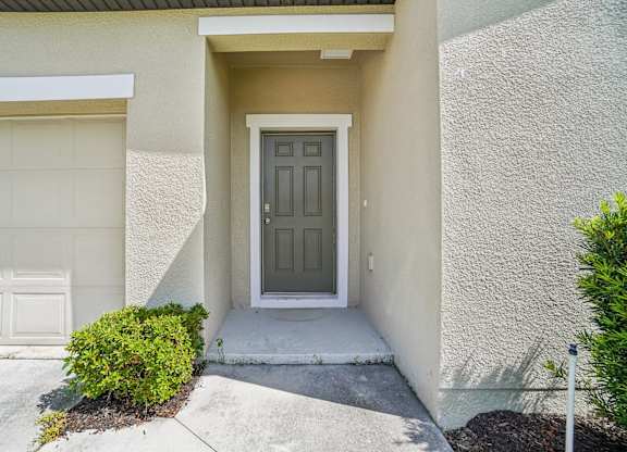 A house with a grey front door and a white garage door.