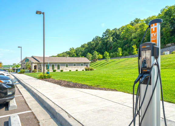 a gas station with a lawn and a building in the background
