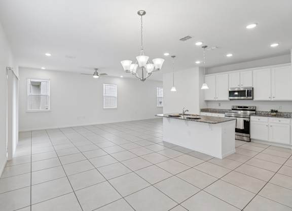 A spacious kitchen with white cabinets and a central island.