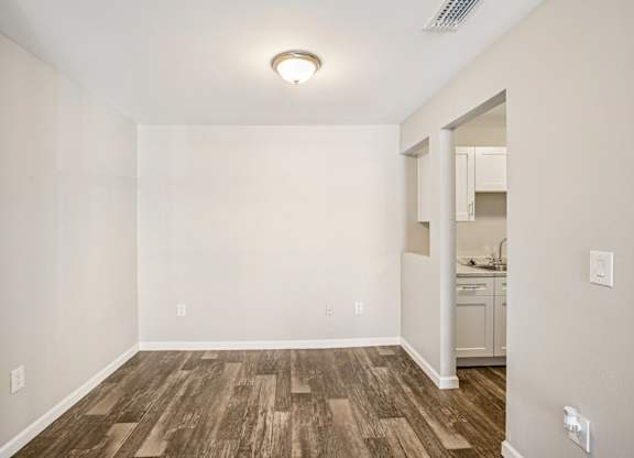 A room with wooden flooring and white walls.