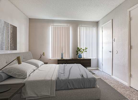 Fort Worth TX Apartments - Monarch Pass - Bedroom with Wall-to-wall Plush Carpeting, Beige Walls, Large Bed, and Windows with Vertical Blinds
