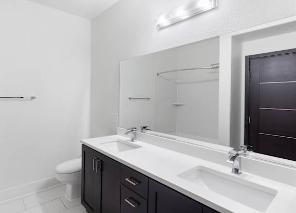 A bathroom with a toilet, sink, and mirror.