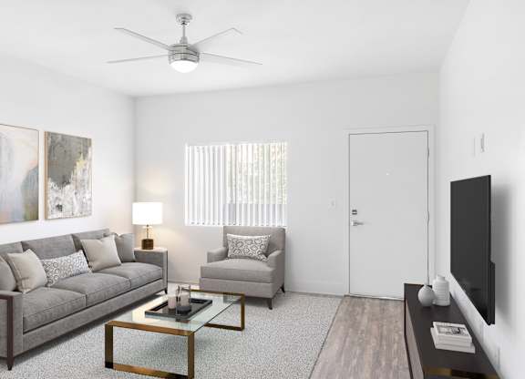 A living room with a grey couch, a coffee table, and a painting on the wall.