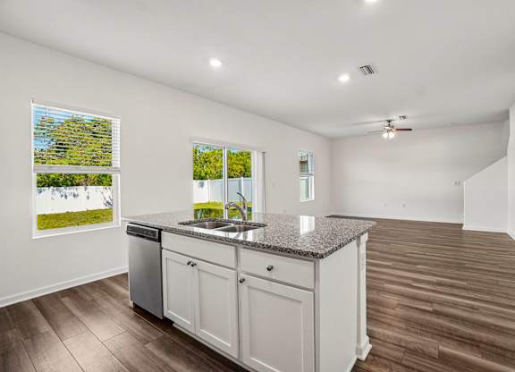 A kitchen with a granite countertop and white cabinets.