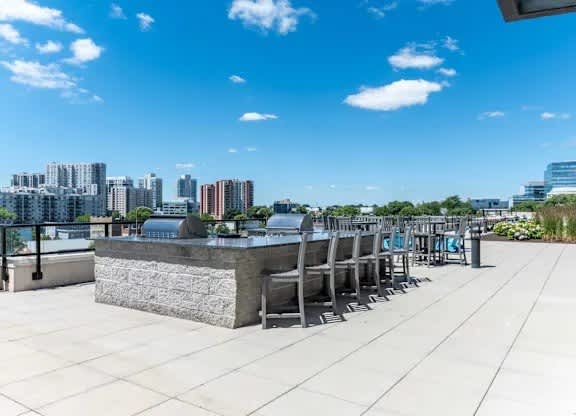 A row of grey chairs are lined up on a patio.