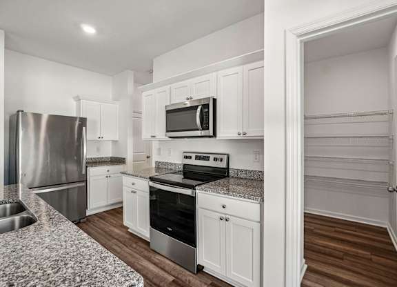 A kitchen with white cabinets and stainless steel appliances.