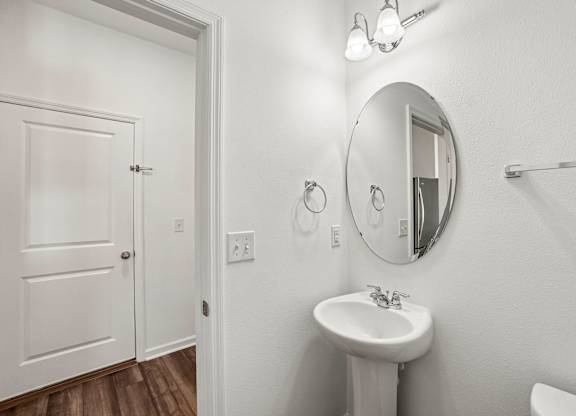 A white bathroom with a sink and mirror.