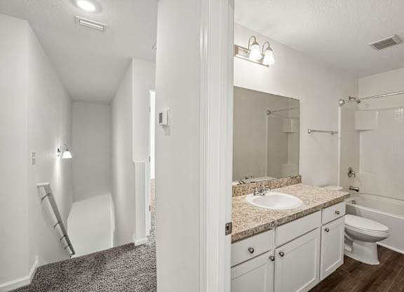 A bathroom with a sink, toilet, and bathtub.