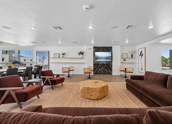 A living room with brown couches and a wooden coffee table.
