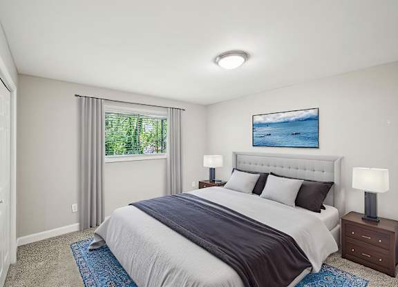 Bedroom with a queen bed, blue accents, and a window view.