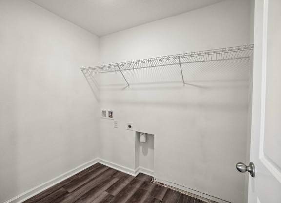 A white wall with a door and a shelf.