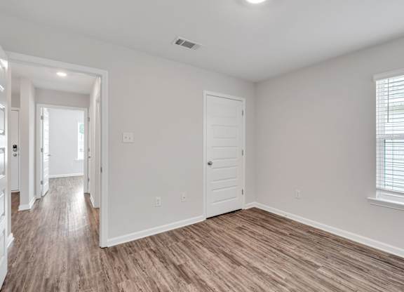 A room with wooden flooring and white walls.