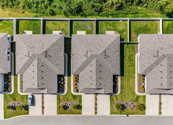A row of houses with a white fence in front.