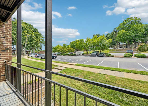 A parking lot with cars and trees in the background.