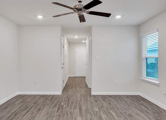 A room with a ceiling fan and lighting fixtures.
