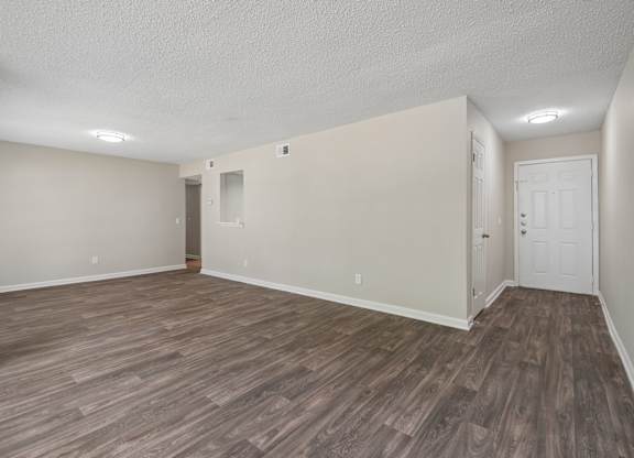 A room with wood flooring and white walls.
