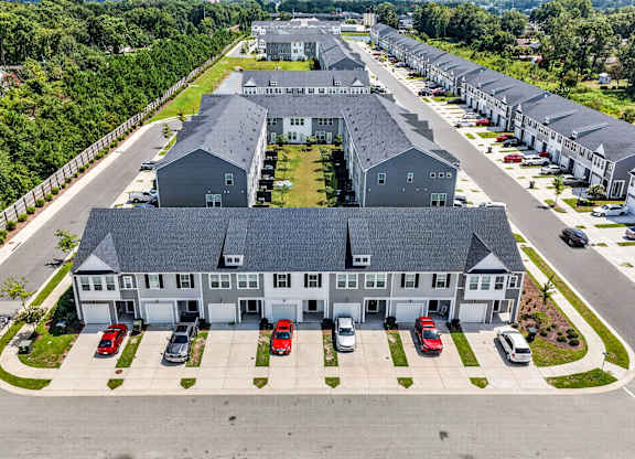 A large grey building with a parking lot in front of it.
