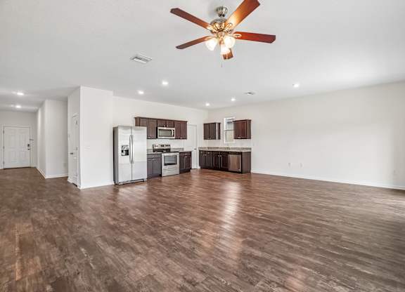 A spacious kitchen with a refrigerator, microwave, oven, and cabinets.