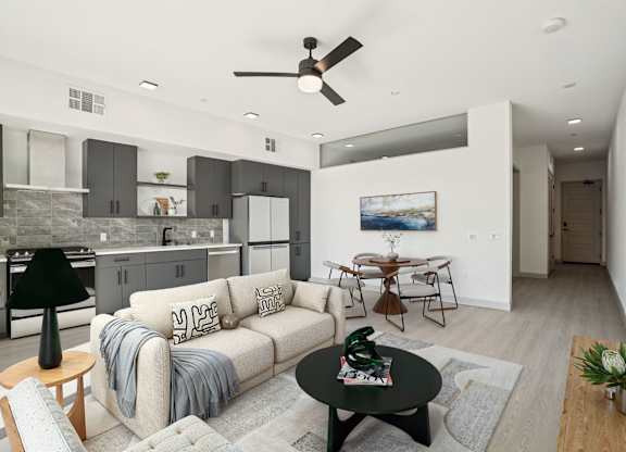A modern living room with a grey couch and a black coffee table.