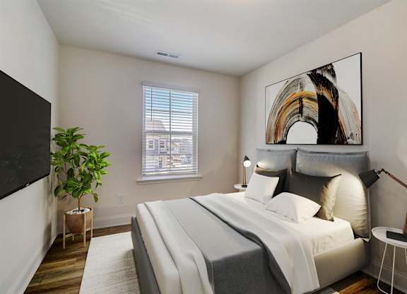A bedroom with a large bed, a potted plant, and a painting on the wall.