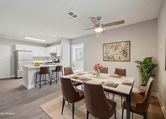 A dining room with brown chairs and a white table.