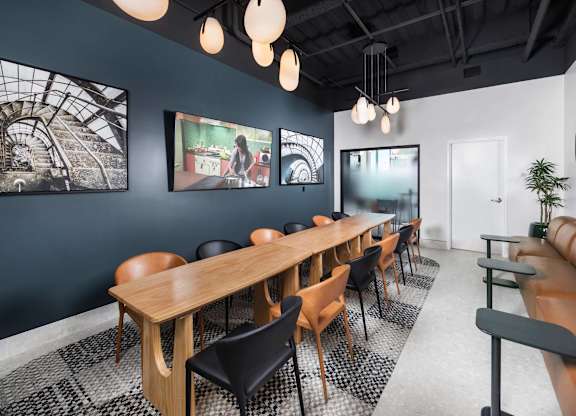 A conference room with a long table and chairs.