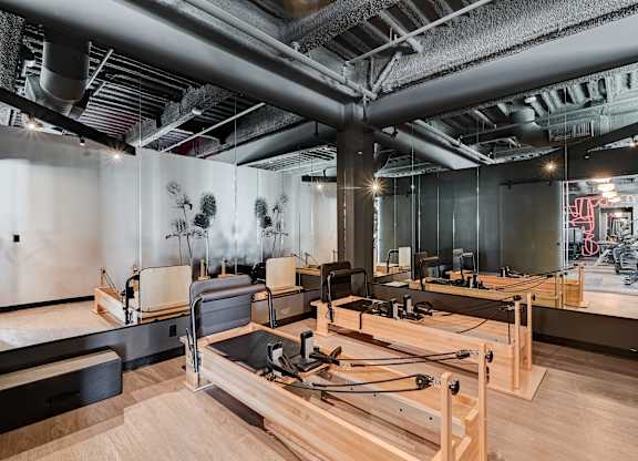 A room with pilates equipment and a mirror on the wall.
