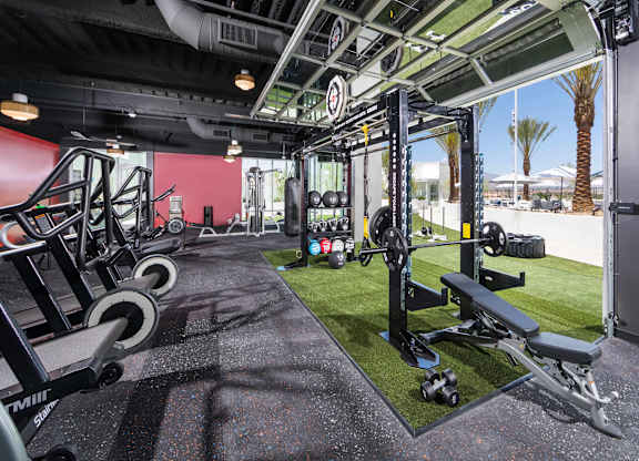 A gym with a red wall and black flooring.
