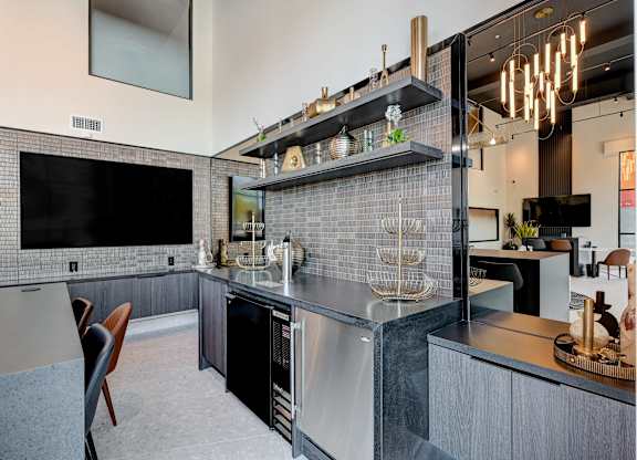 A modern kitchen with a black fridge and a black countertop.