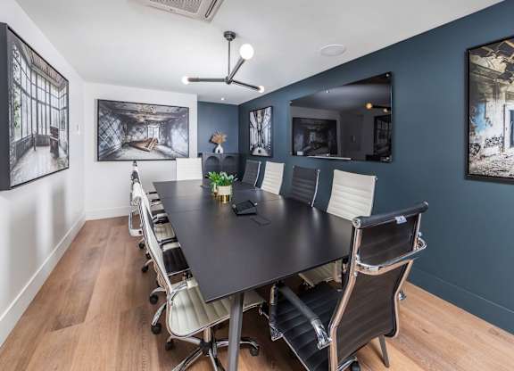A conference room with a long table and chairs.