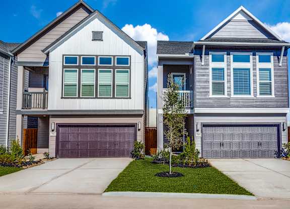 a house with two garage doors and a yard
