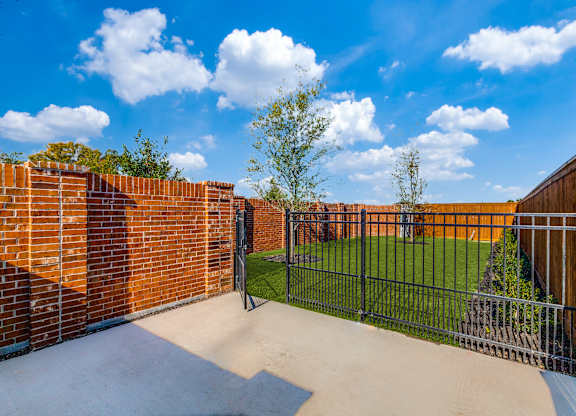 Two-Bedroom Homes for Rent in Houston, TX - East Heights - Dog Park with Green Grass, Trees, and Gated Fence.