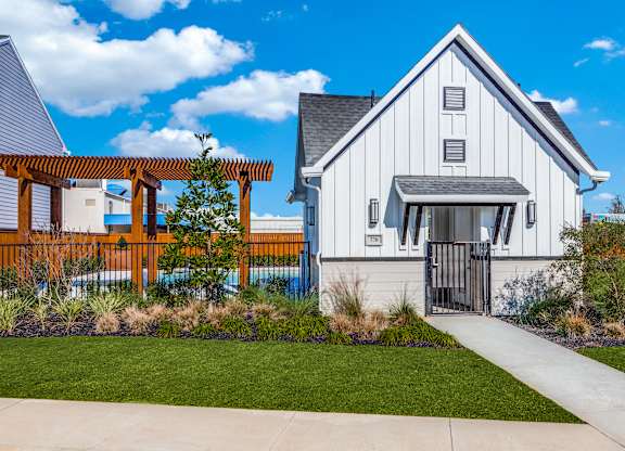 a white home with a walkway and a wooden fence