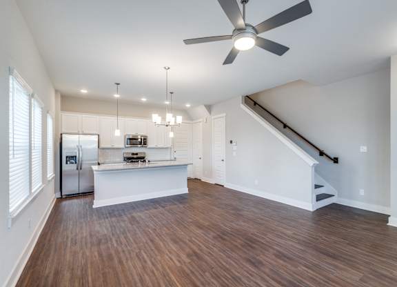 an open living room and kitchen with a ceiling fan