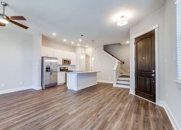 	Houses for Rent in Houston, TX - East Heights - Living Room with Open Floor Plan, Ceiling Fan, Wood-Style Flooring, and Front Door.