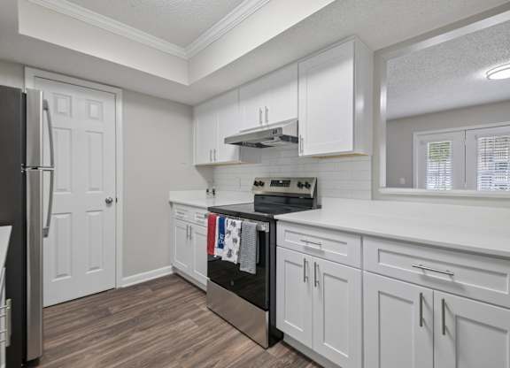 A kitchen with white cabinets and a black stove top oven.