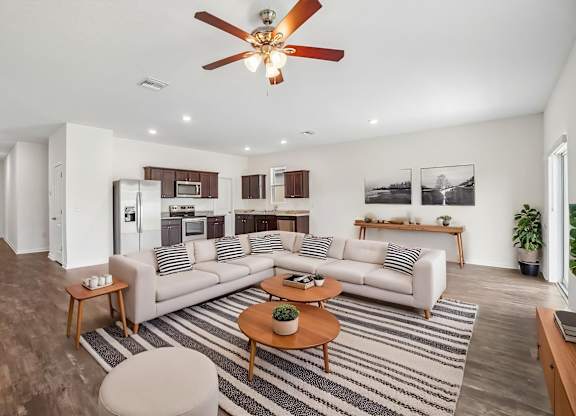 A living room with a striped rug and a white couch.