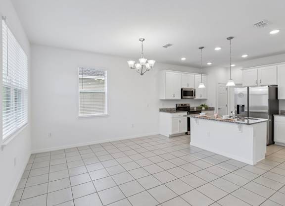 A white kitchen with a large island in the middle.