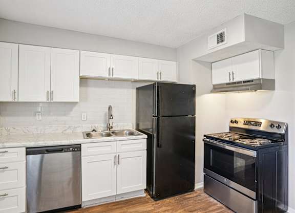 A kitchen with black appliances and white cabinets.