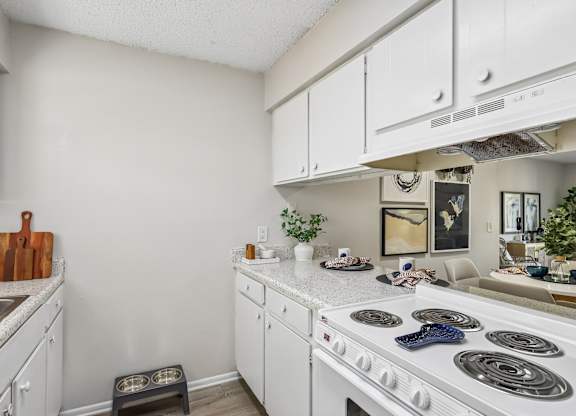 A kitchen with white cabinets and a white stove top.