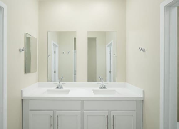 A bathroom with a white counter and two sinks.