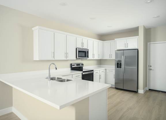 A kitchen with white cabinets and appliances.