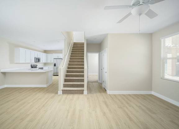 A room with a staircase and a fan.